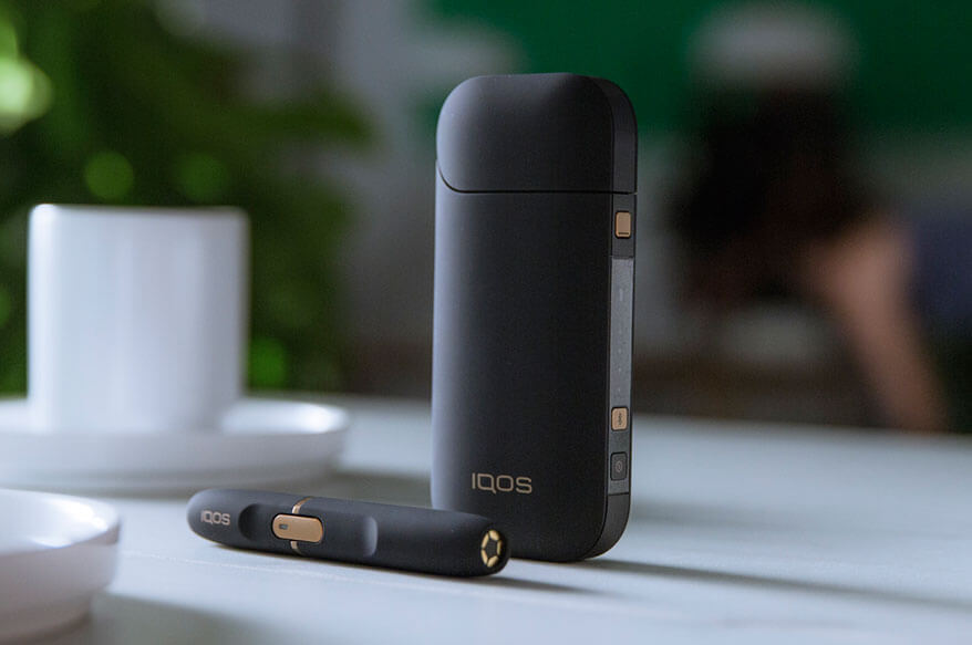 IQOS 2.4 PLUS cargador de bolsillo y dispositivo en la mesa