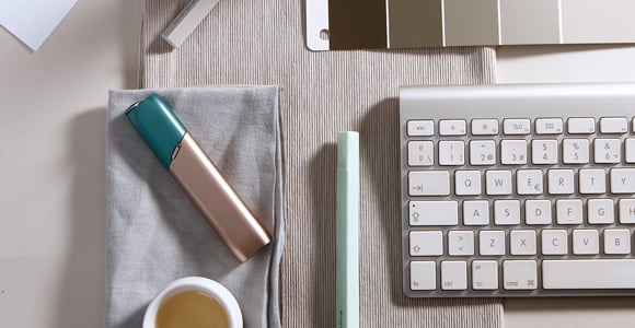 Green and coppery IQOS 3 MULTI kit on a working desk