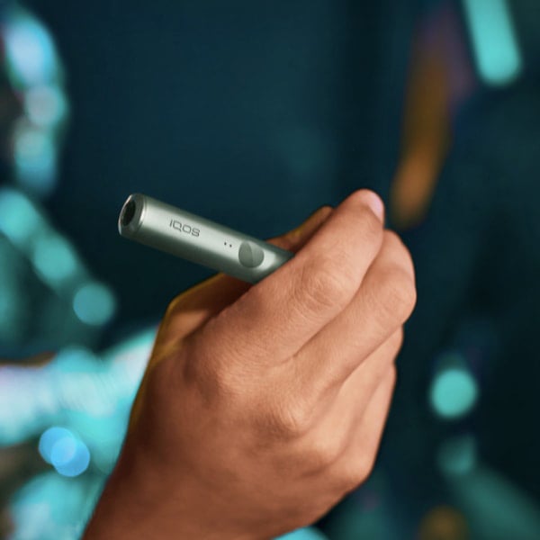 A person placing a TEREA stick into an IQOS ILUMA Holder