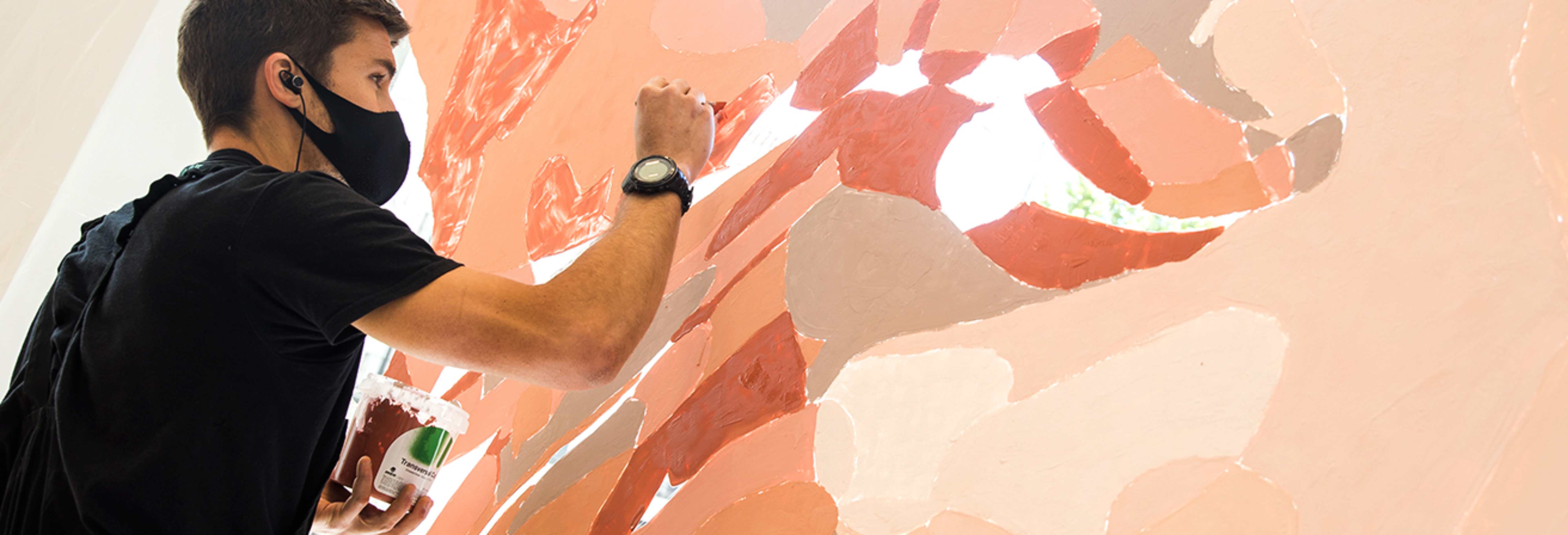 Artista Taquen pintando el mural IQOS.