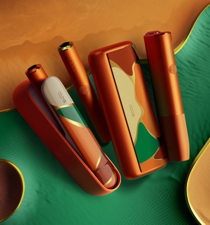 Nuevo IQOS ILUMA OASIS Edición Limitada: 3 dispositivos para calentar tabaco sobre fondo dorado y verde