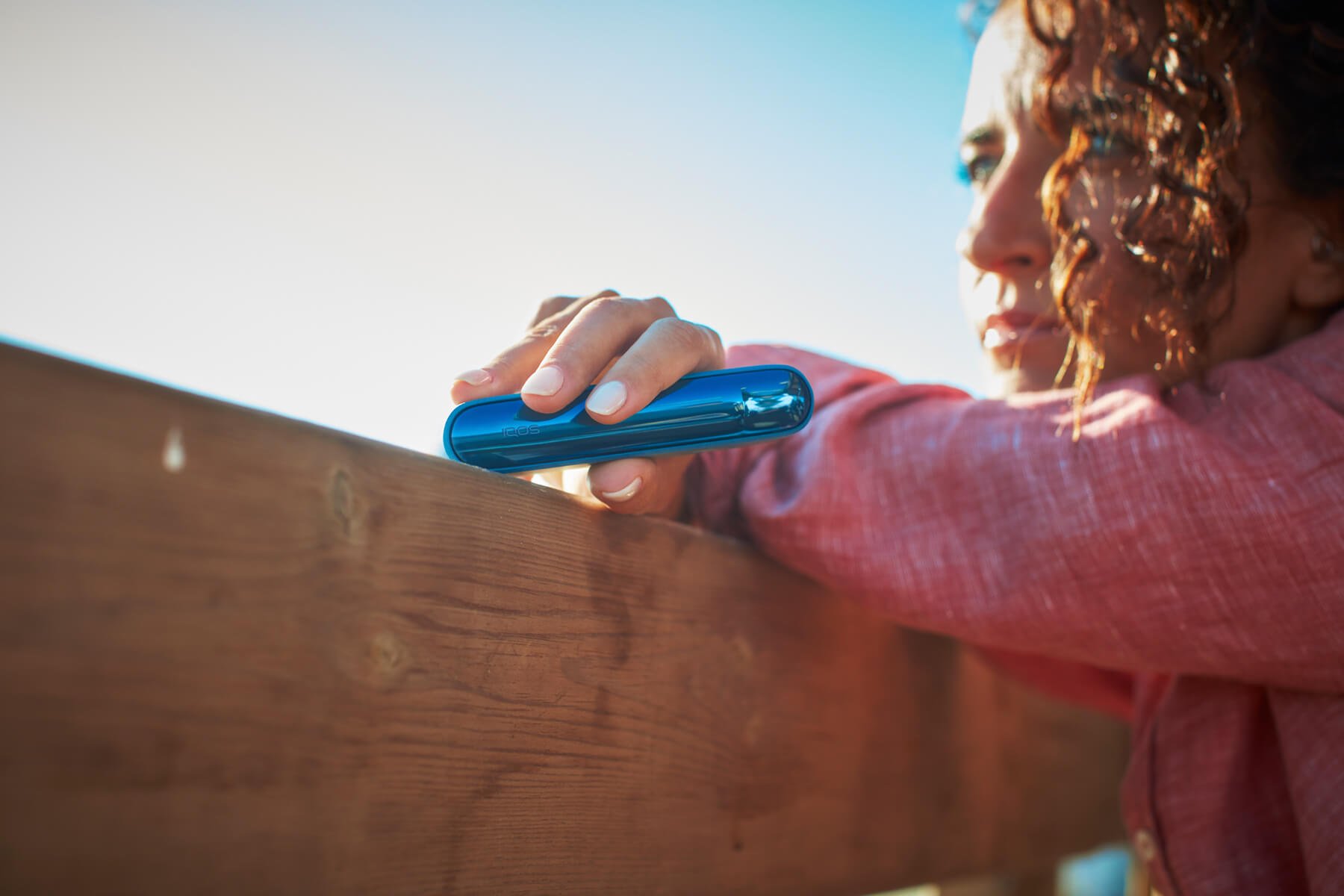 Chica con dispositivo IQOS ILUMA