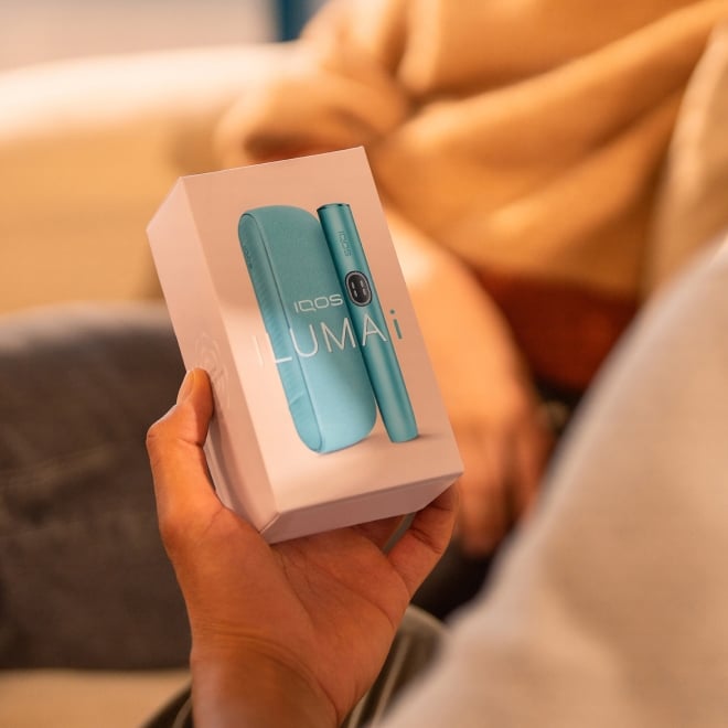 Mano sujetando caja de IQOS ILUMA i Azul Brisa