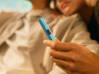 Mano de mujer sujetado el holder de IQOS ILUMA i Azul Brisa