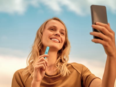 Mujer con el holder de IQOS ILUMA i Azul Brisa