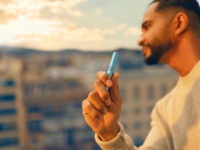 Hombre con el holder de IQOS ILUMA i PRIME Azul Brisa