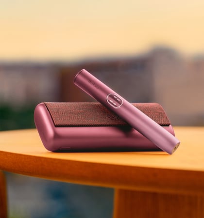 Dispositivo IQOS ILUMA i Rojo Granate en una mesa