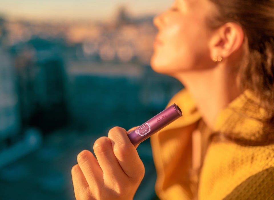 Mujer sujetando el holder del IQOS ILUMA i Rojo Granate