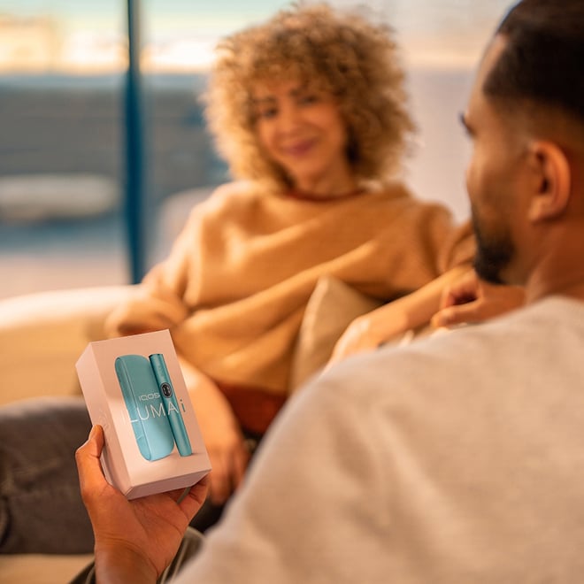 Hombre con la caja de IQOS ILUMA i Azul Brisa