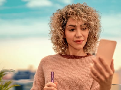 Mujer con el holder de IQOS ILUMA i PRIME Rojo Granate
