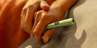 Manos sosteniendo un dipositivo IQOS ILUMA i MID