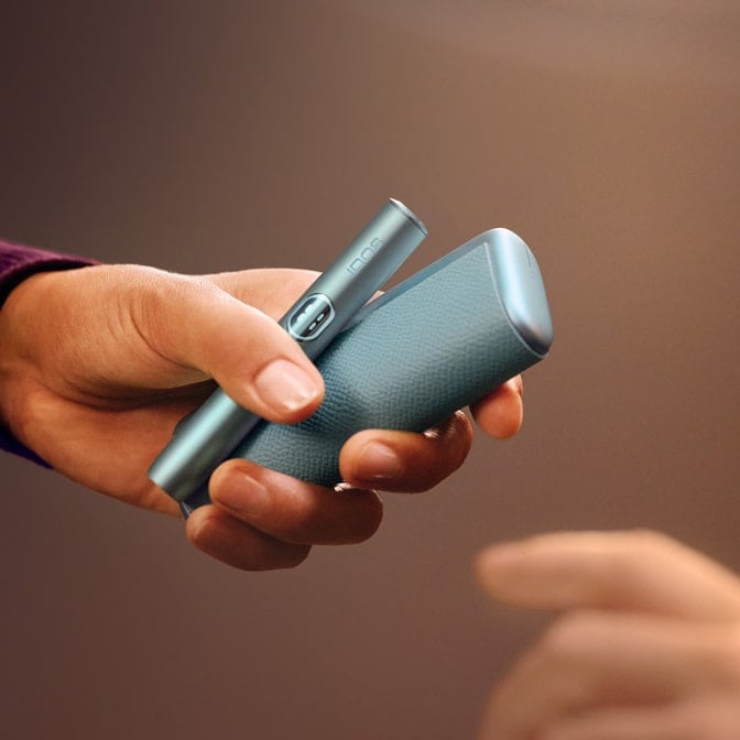 Mano sujetado dispositivo y holder de IQOS ILUMA i PRIME en Azul Brisa 