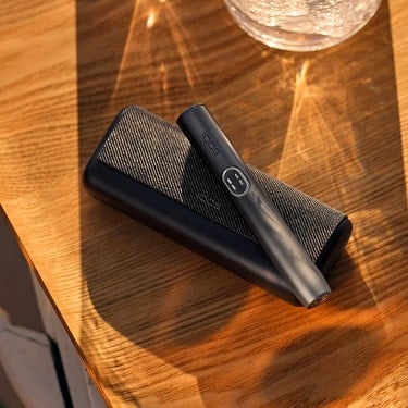 Cargador de bolsillo y Holder IQOS ILUMA i PRIME Negro Medianoche encima de una mesa de madera