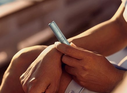 Mano sujetando el holder de IQOS ILUMA i PRIME en Azul Brisa