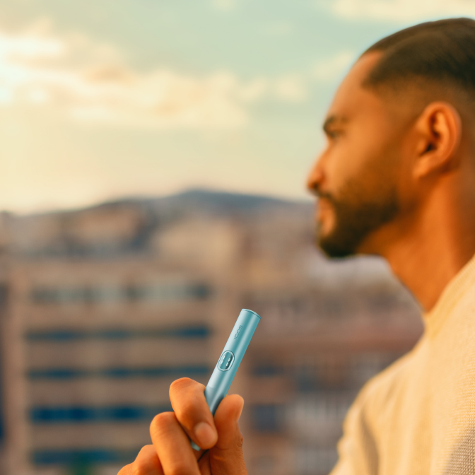 una persona con un iluma i prime azul mirando al horizonte y sosteniendo el dispositivo con la mano