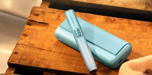IQOS ILUMA i apoyado en una madera 
