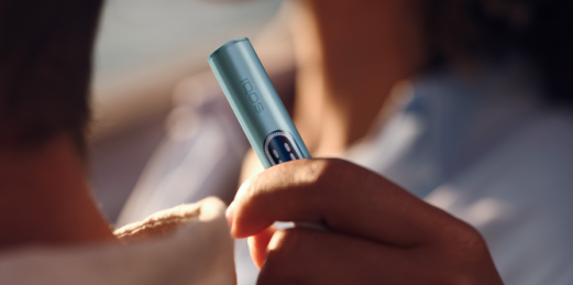 Mujer con un IQOS ILUMA i apoyada en el hombro de un hombre