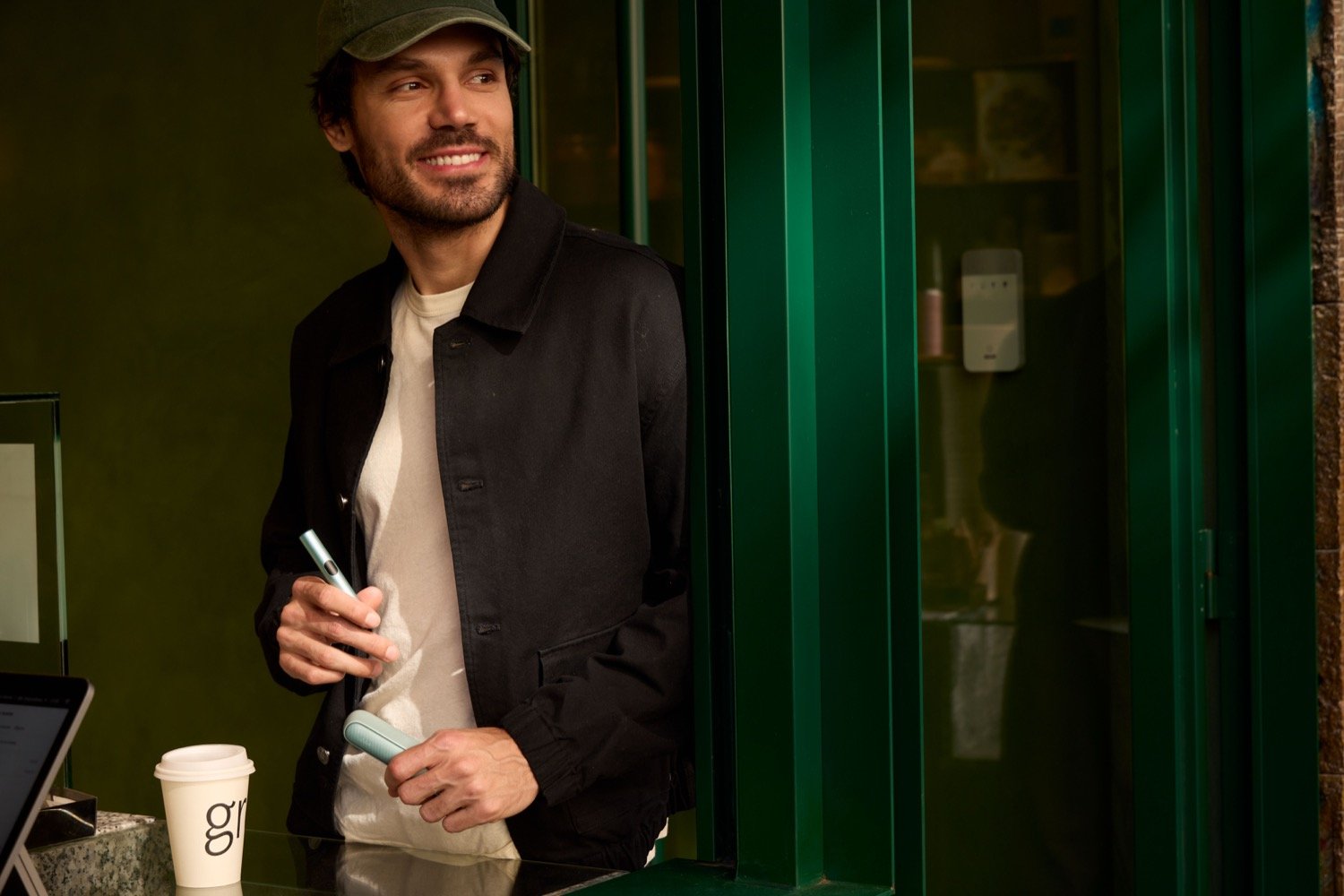 Una persona sonriendo con su dispositivo IQOS ILUMA