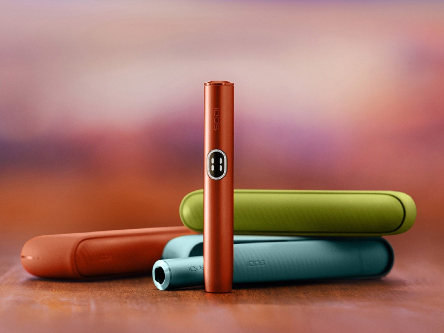 IQOS ILUMA de varios colocados sobre un fondo degradado de color naranja