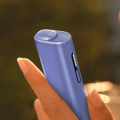 Una mano agarrando un IQOS ILUMA I ONE morado