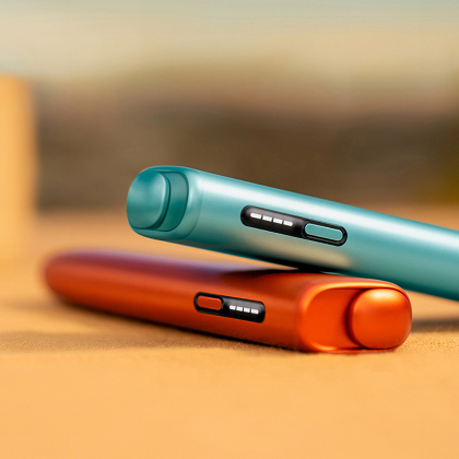 Dos IQOS ILUMA I ONE azul y naranja apoyados uno sobre el otro