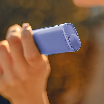 Mano sosteniendo un dispositivo IQOS ILUMA I ONE Morado
