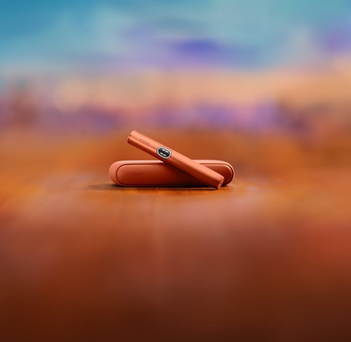 IQOS ILUMA I terracota sobre un fondo de color terracota