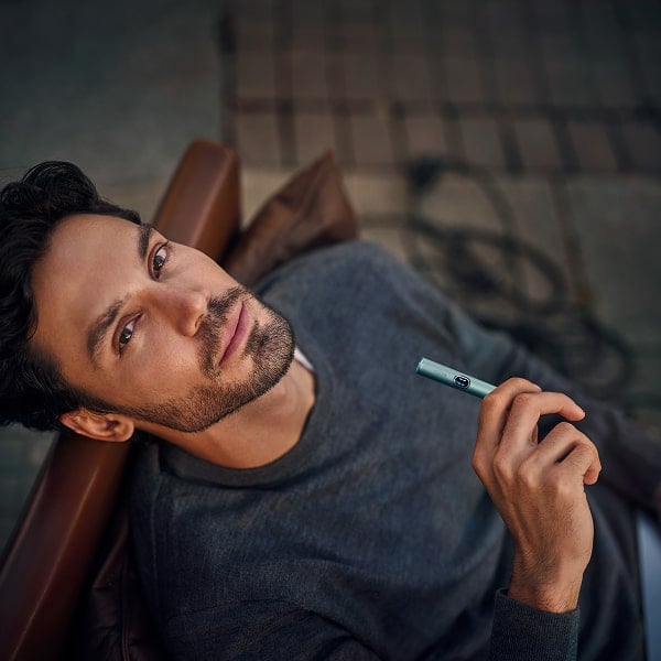 Hombre con holder de IQOS ILUMA i en Azul Brisa 