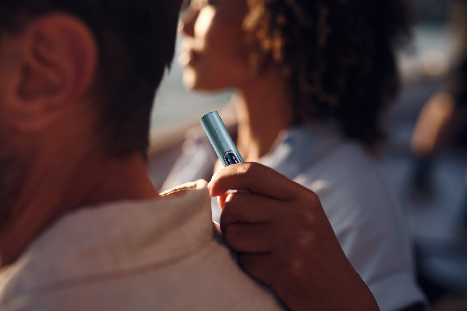 Mujer con holder de IQOS ILUMA i Azul Brisa en la mano