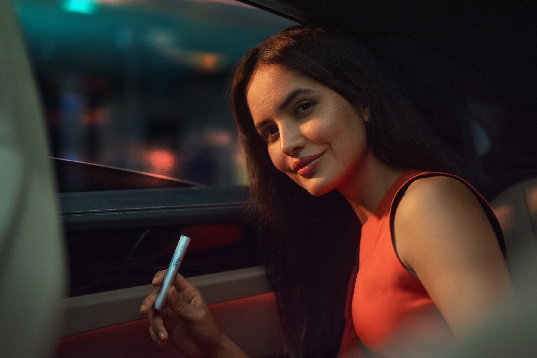 Chica con IQOS ILUMA i en coche