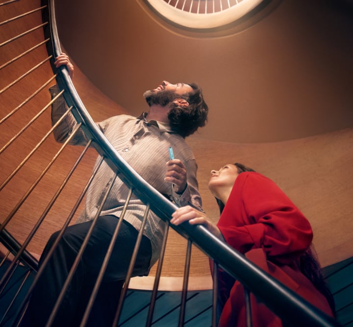Hombre y mujer en una escalera IQOS ILUMA i