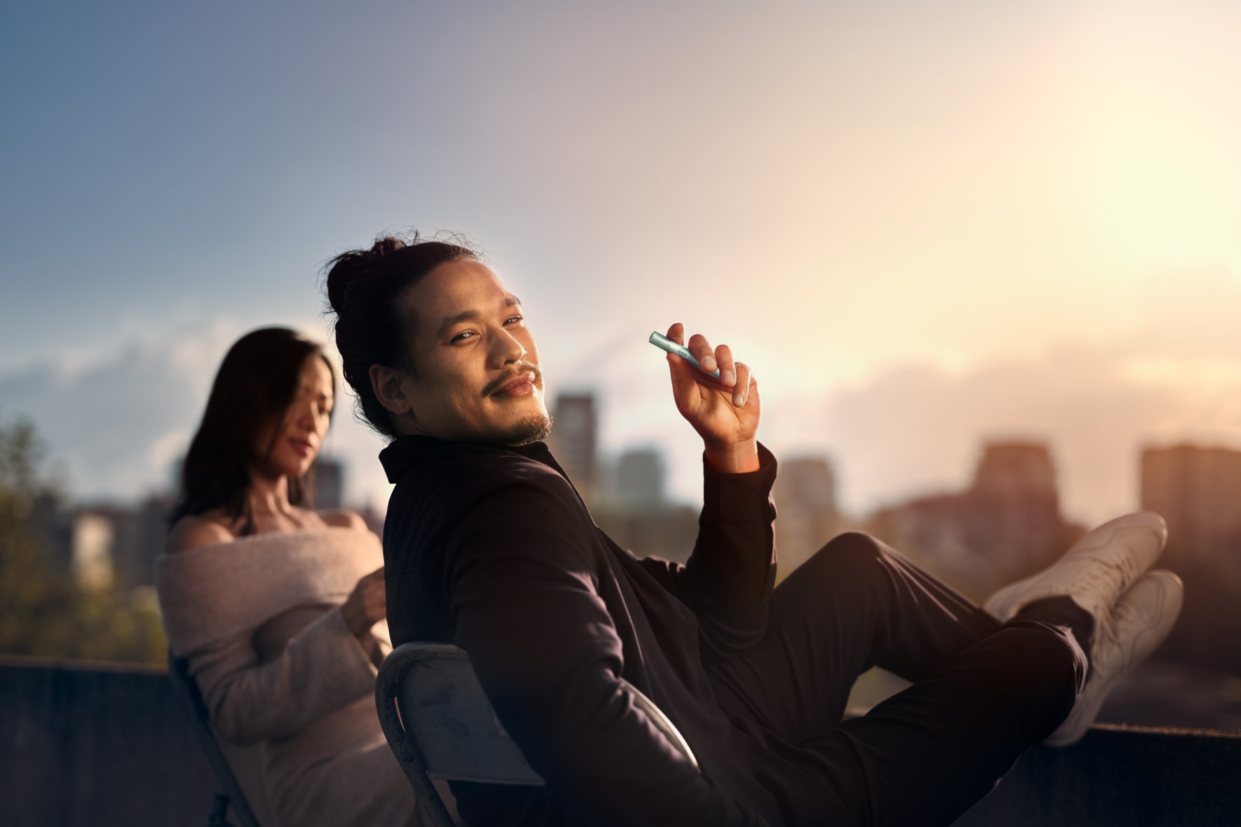 Hombre en una azotea con IQOS ILUMA i One