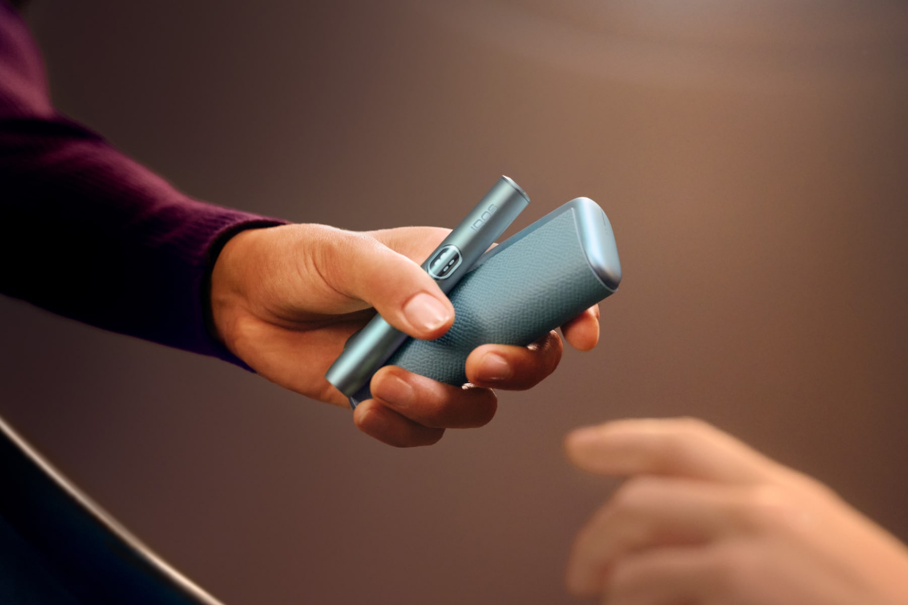 Mujer entregando IQOS ILUMA i