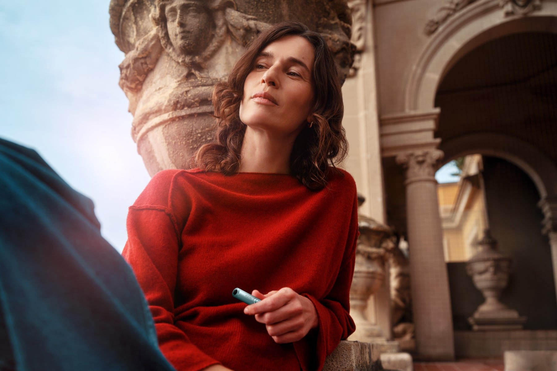 Mujer con un monumento detrás_IQOS ILUMA i