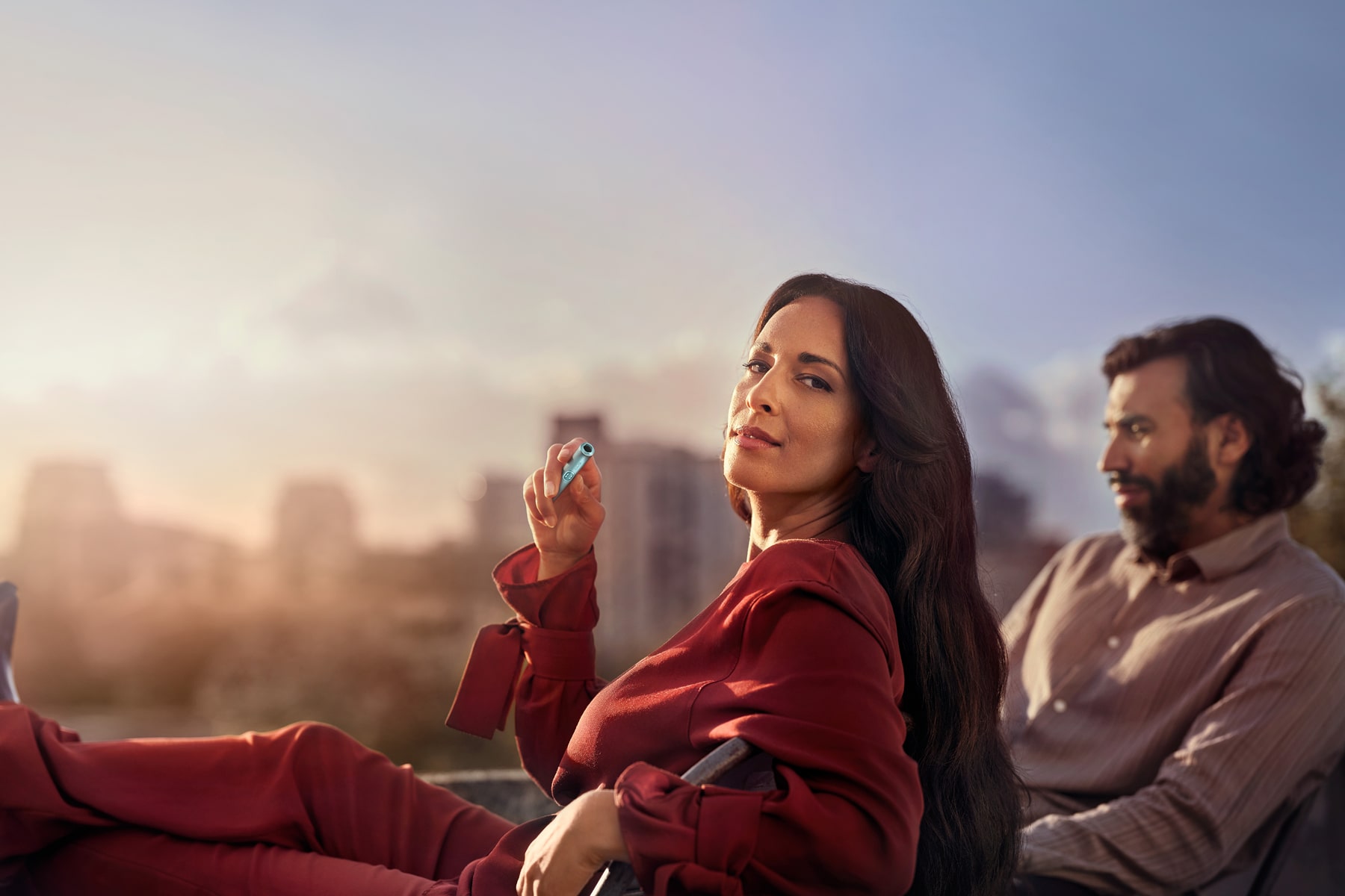 Mujer y hombre en una terraza con IQOS ILUMA i
