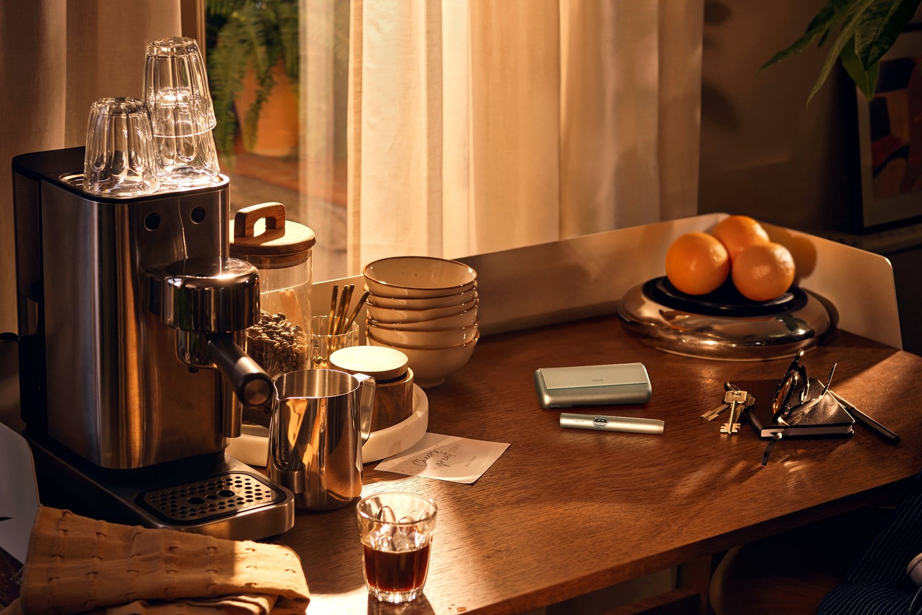 IQOS ILUMA i PRIME Azul Brisa encima de una mesa con una cafetera