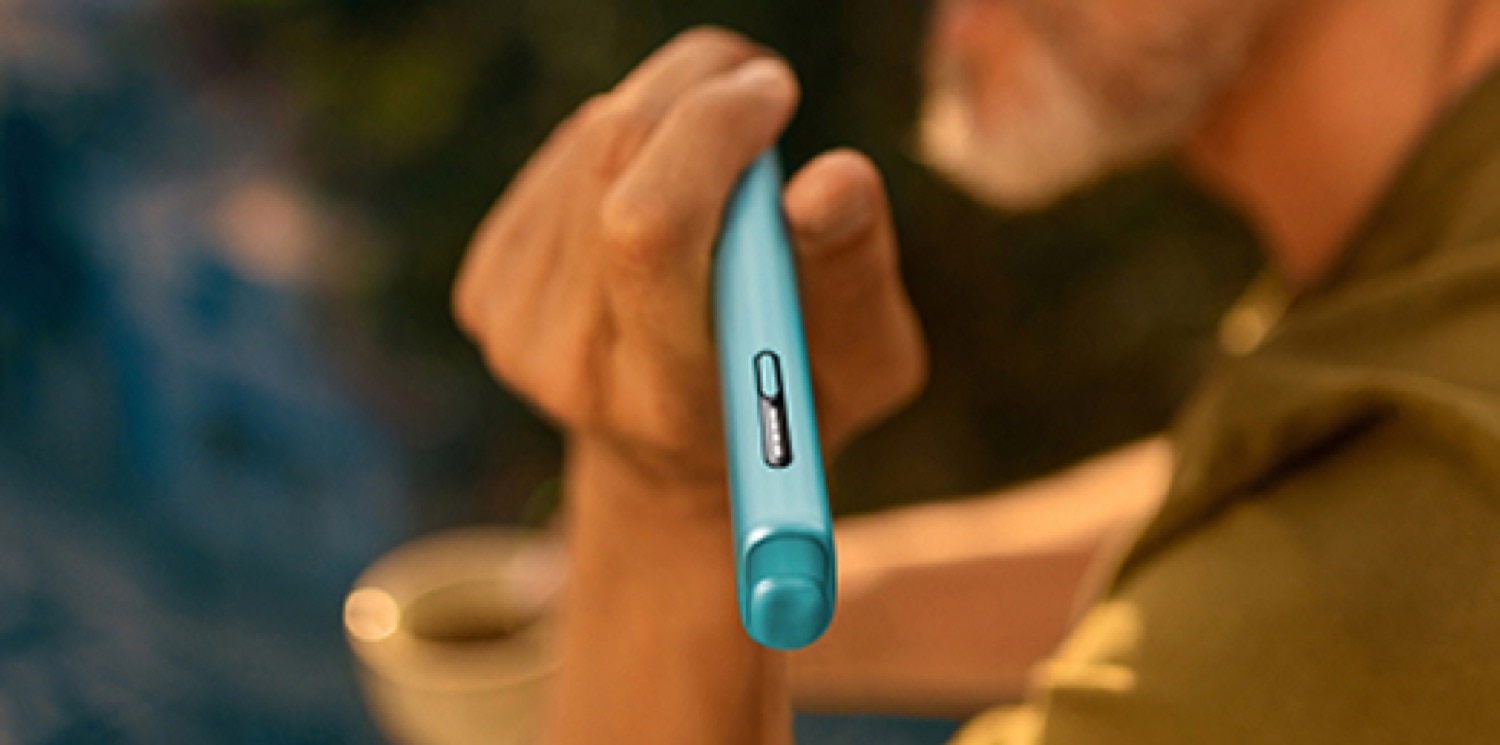Una persona sosteniendo un dispositivo IQOS azul