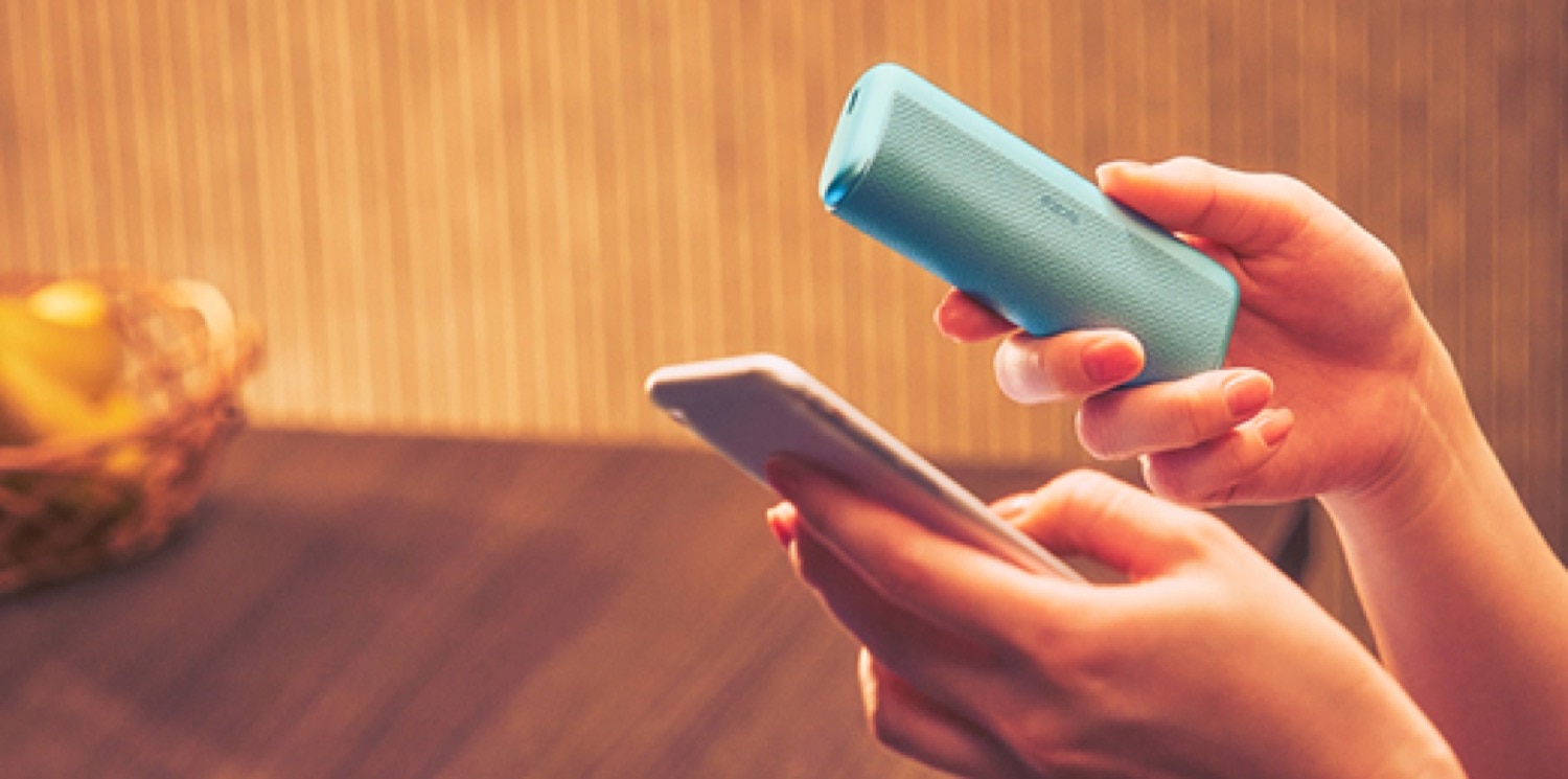 Unas manos agarrando un dispositivo IQOS y un móvil