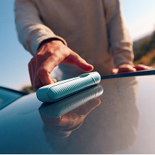 Persona cogiendo un IQPS del capó de un coche