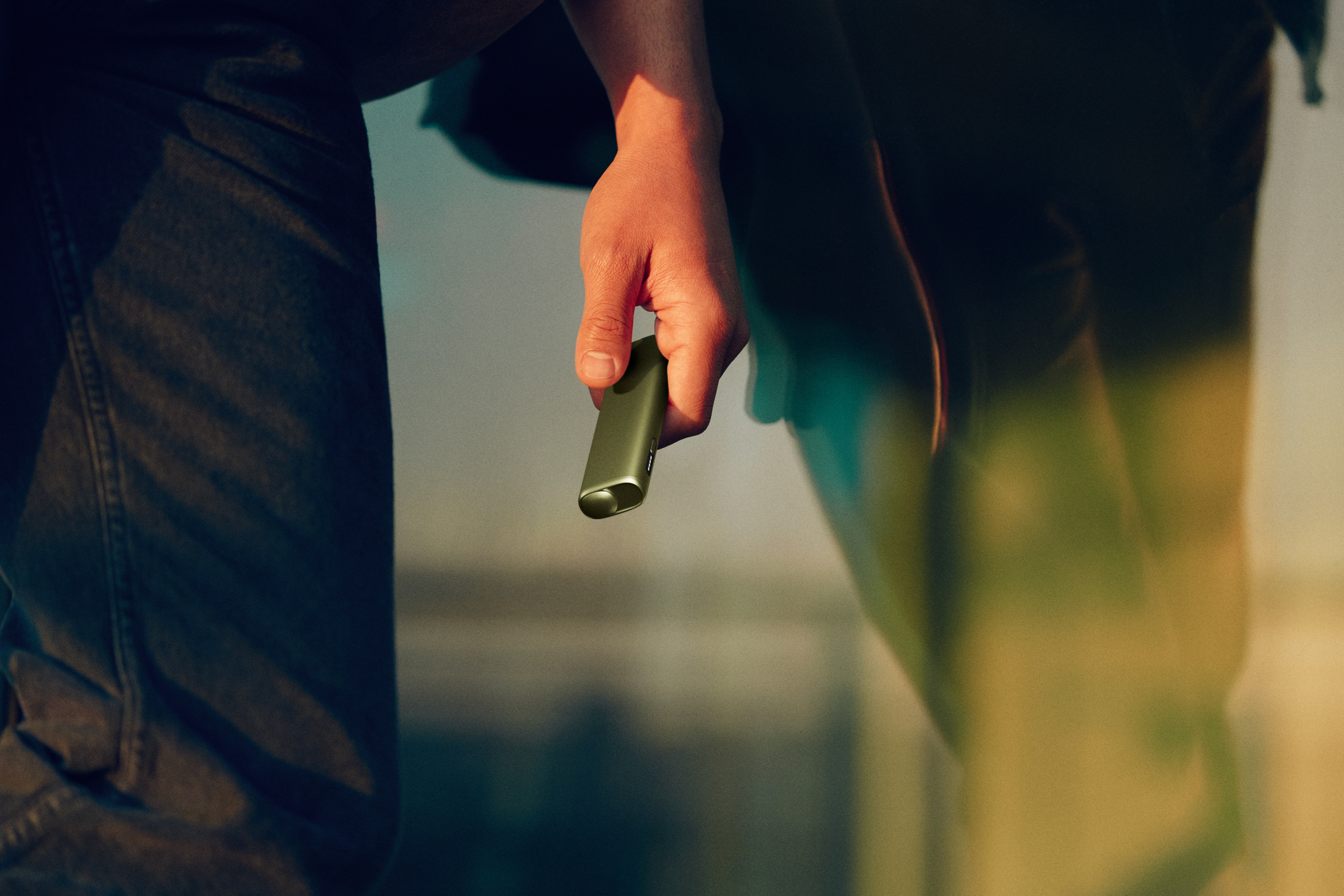 Mano sujetando un IQOS verde hoja
