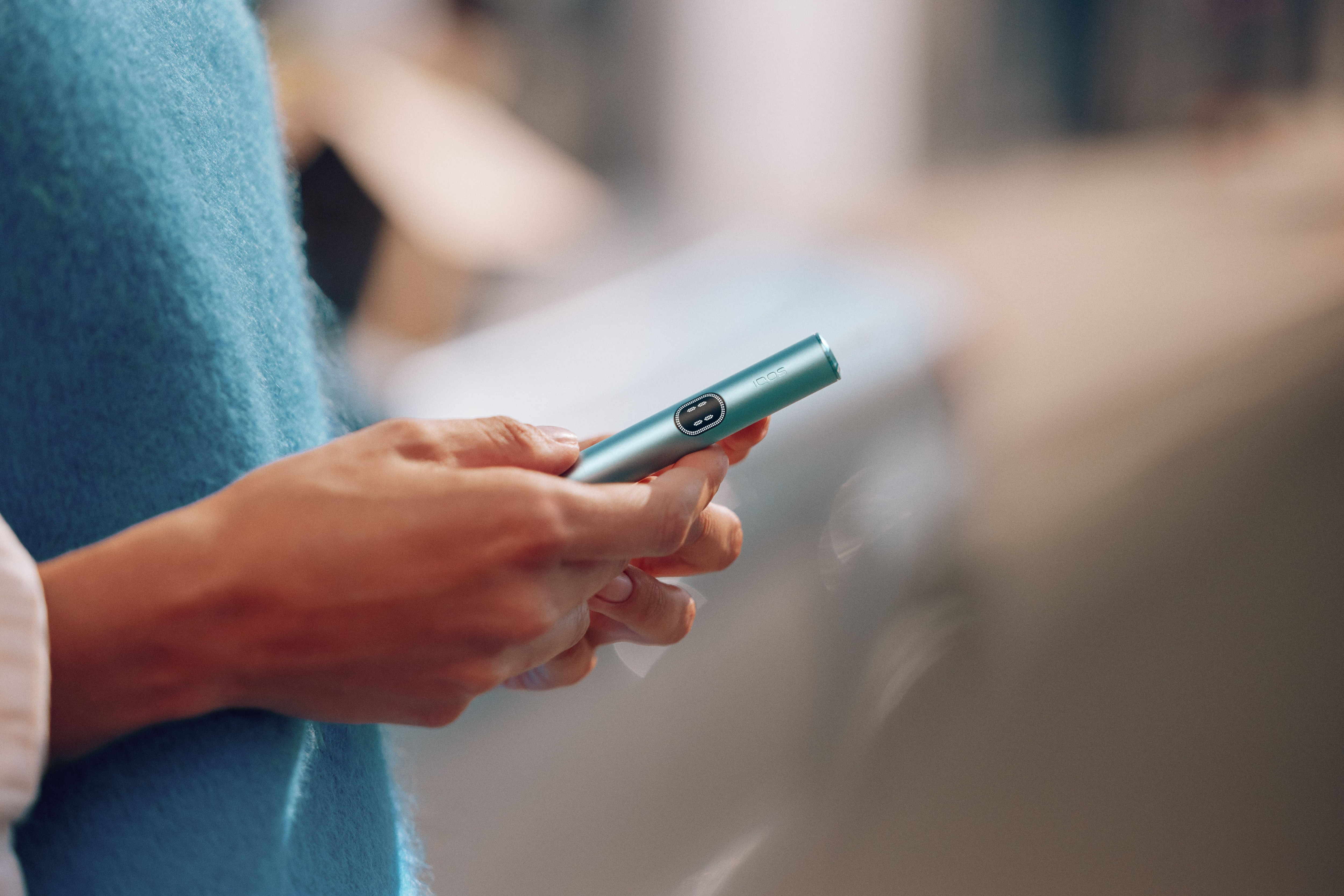 Mujer sujetando un IQOS