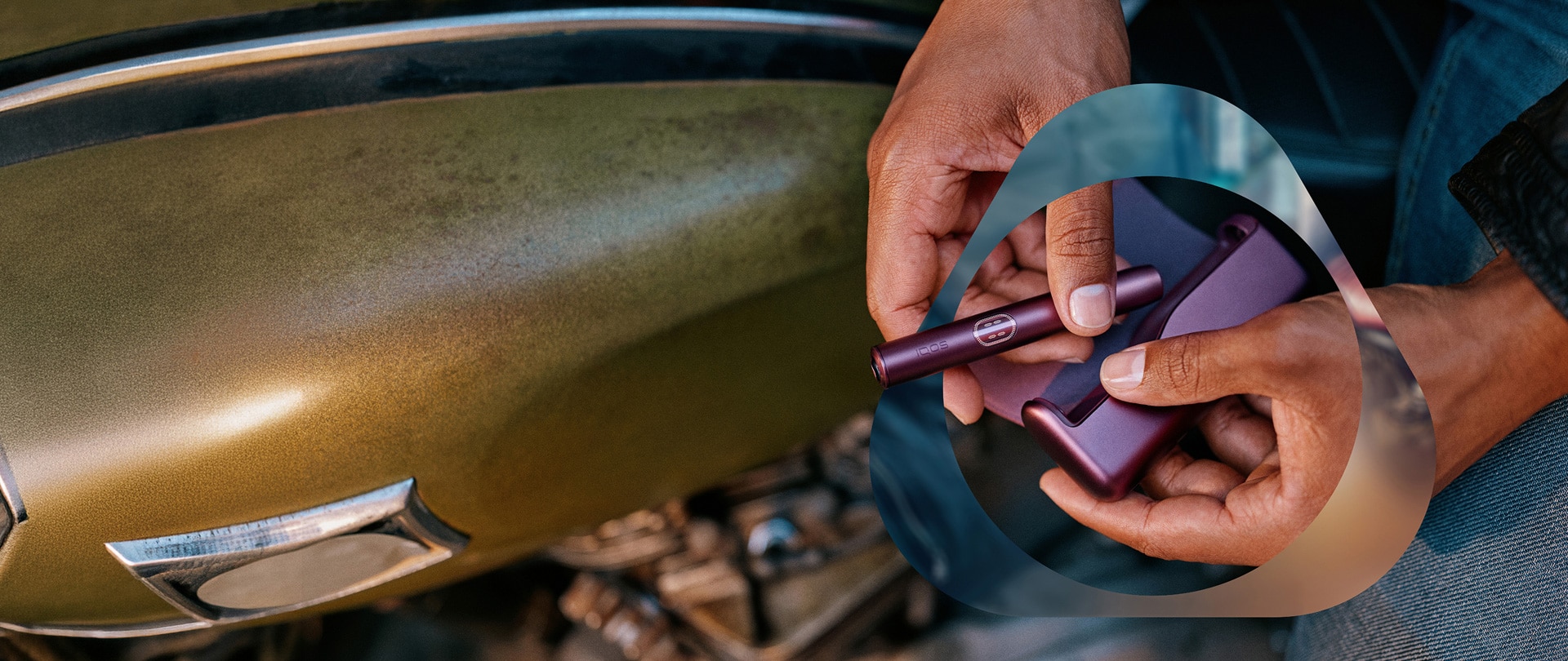 Usuario de IQOS sosteniendo su dispositivo al lado de su moto