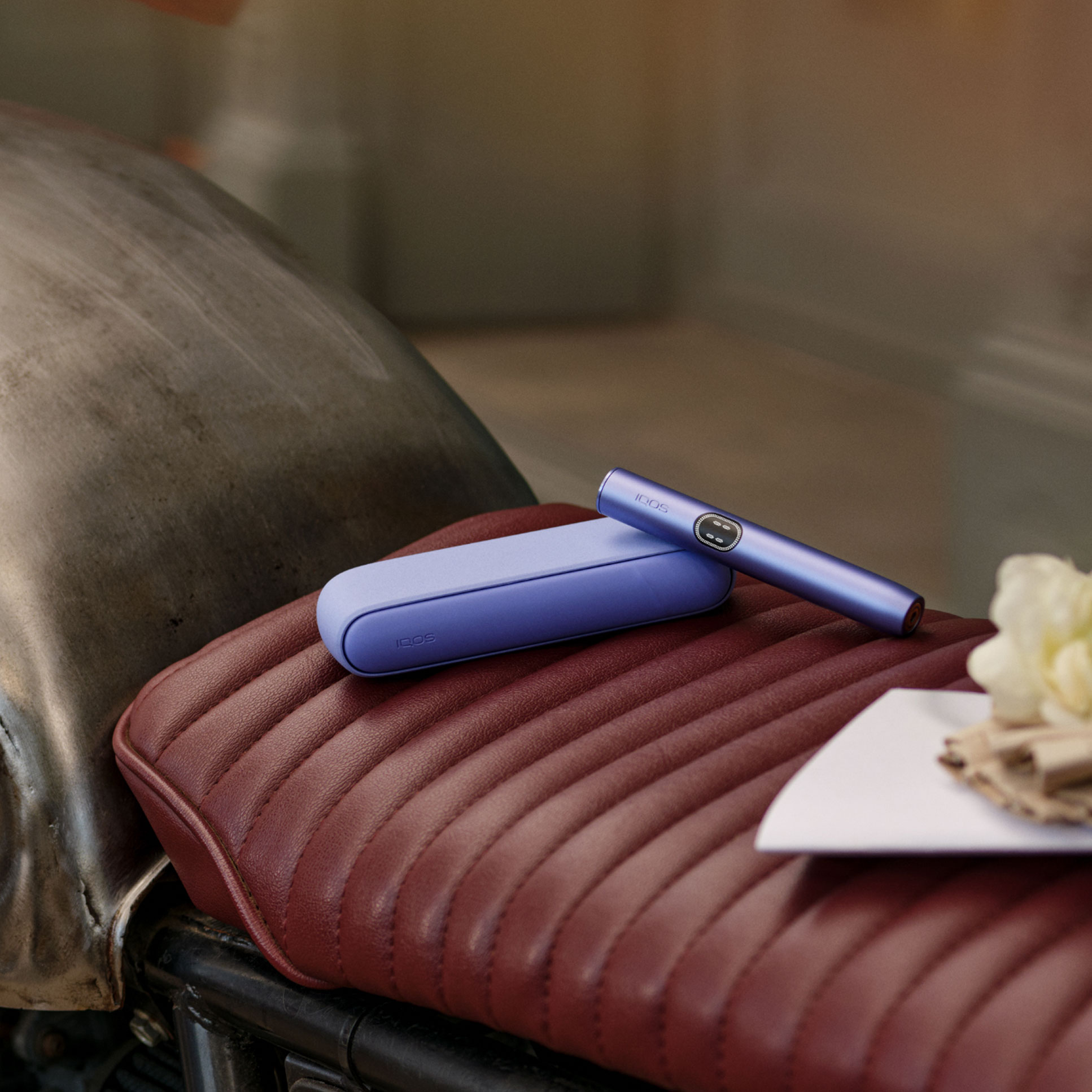 Un dispositivo IQOS ILUMA i sobre el asiento de una motocicleta