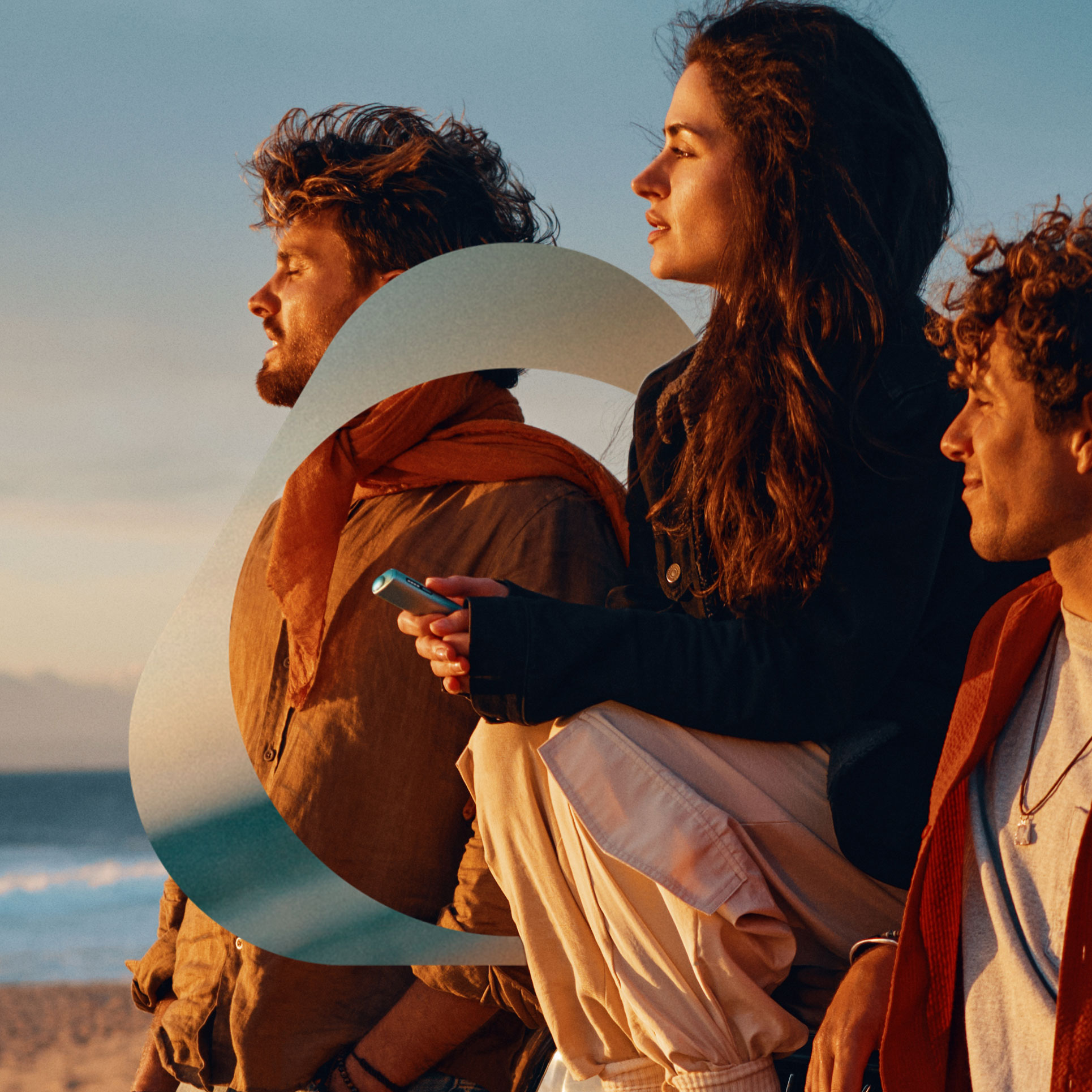 Un grupo de usuarios de IQOS en la playa al atardecer