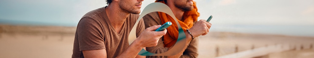 Dos personas con IQOS ILUMA i ONE breeze blue en la mano