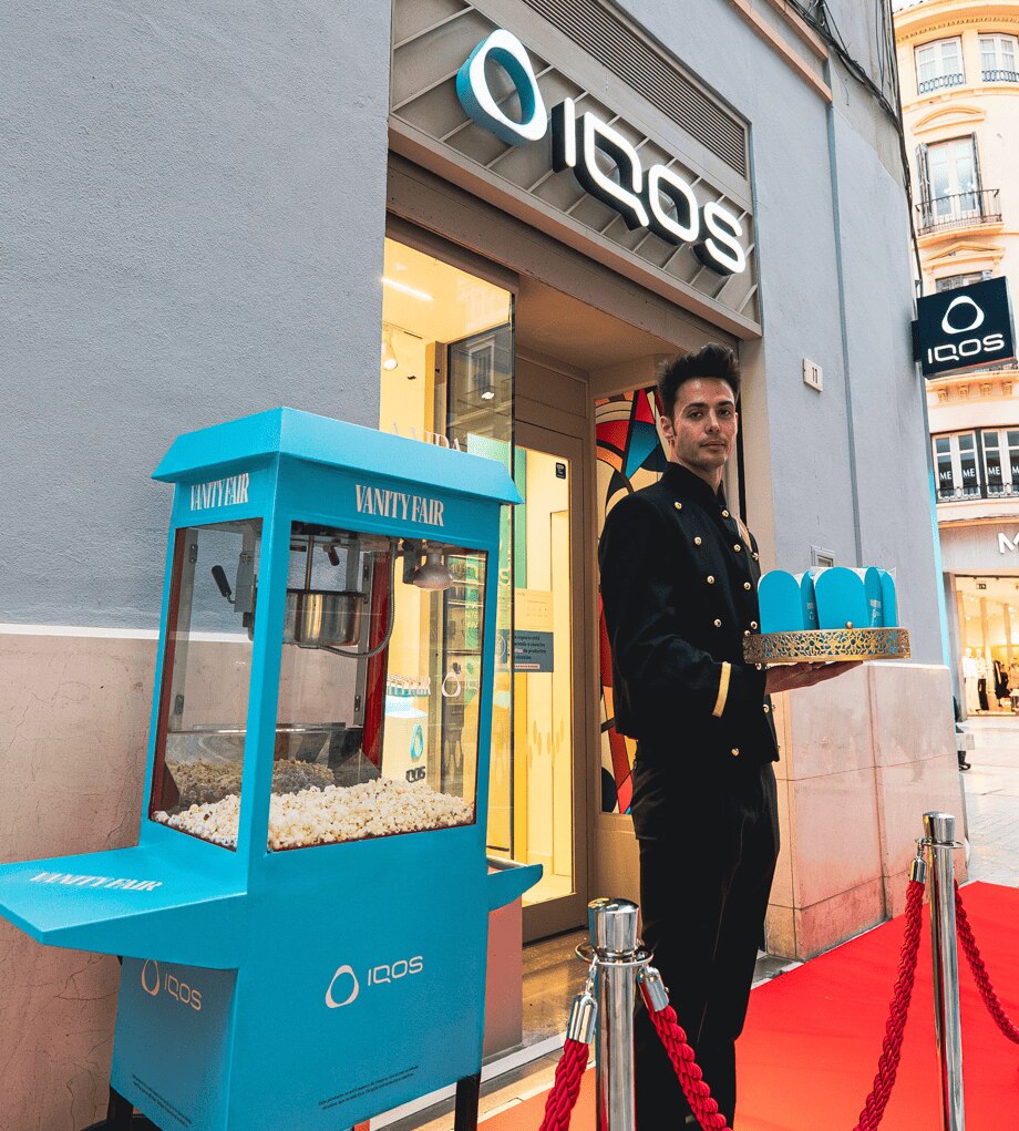 Boutique Málaga, chico sujetando unas palomitas con el logo de IQOS y vanity fair
