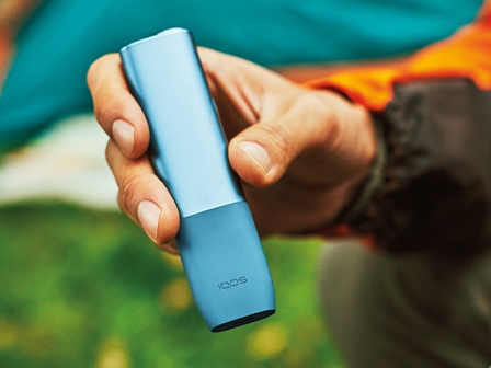 Usuario de IQOS sosteniendo IQOS ILUMA ONE