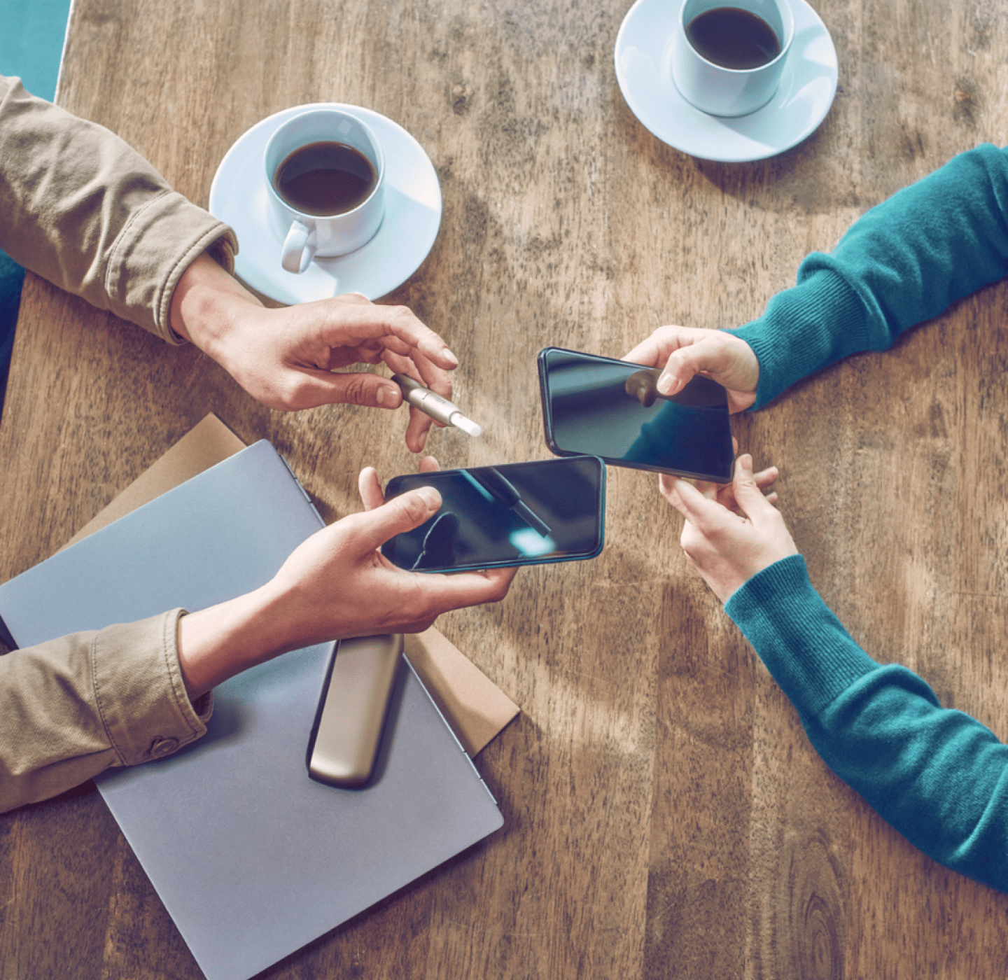 Manos sosteniendo teléfonos intercambiando un código de recomendación IQOS para comprar un dispositivo IQOS con descuento para nuevos usuarios